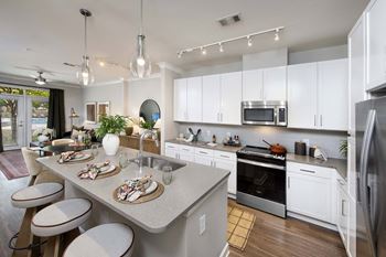 A modern kitchen with a dining table set for two.